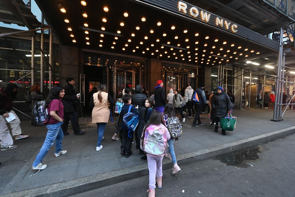 For Sunday News, a group of people gather outside Row NYC hotel on 8th Ave and W. 45th St., where migrants now live and face various issues.