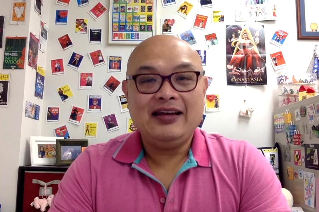 Screenshot of Rachmad Tjachyadi seen speaking in a YouTube video, seen with bulletin board behind him, wearing glasses and a pink polo shirt.