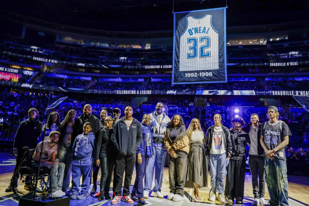 Shaquille O'Neal is joined by his family as his jersey number is retired by the Orlando Magic after the team's NBA basketball game against the Oklahoma City Thunder.