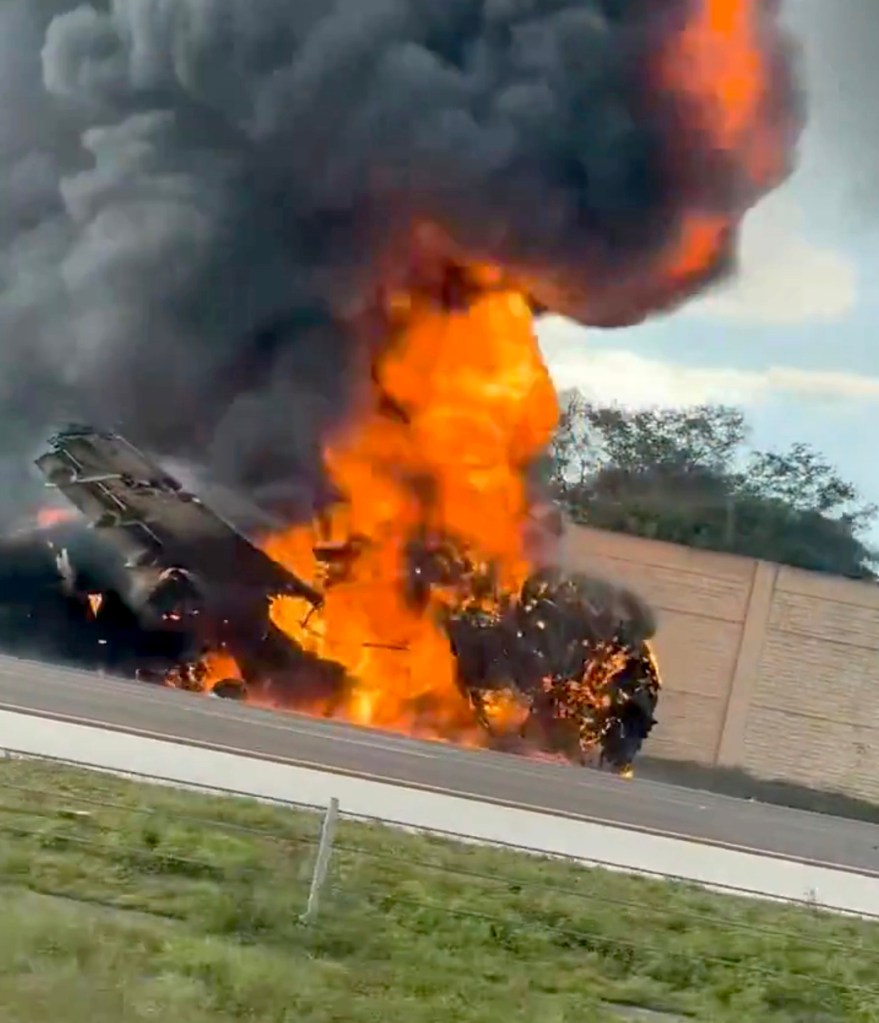 Video posted on social media shows the aircraft completely engulfed in flames in the middle of the southbound lane, spewing black smoke as halted drivers look on.