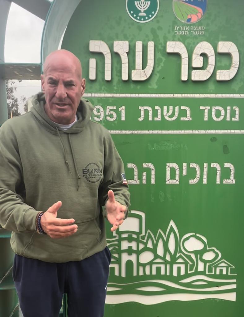 Sid Rosenberg in front of a Hebrew sign