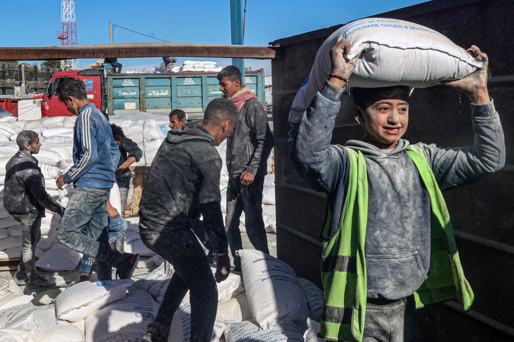 Workers unload bags of humanitarian aid that entered Gaza by truck through a border crossing in Rafah.