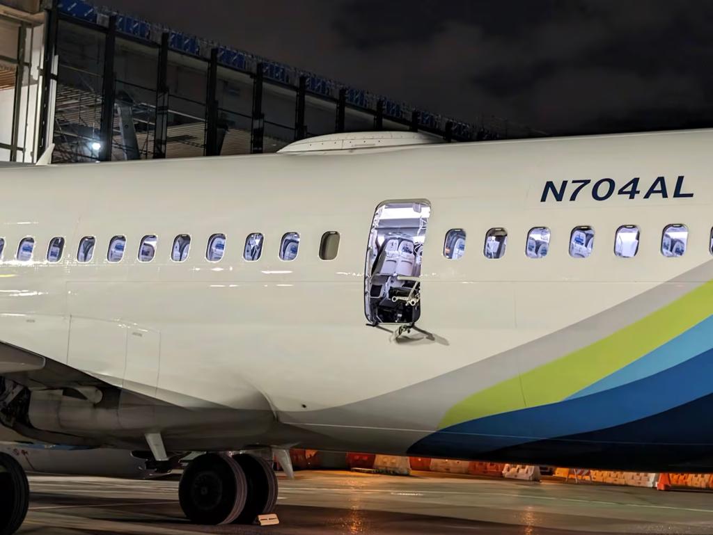 Alaska Airlines plane on the tarmac with emergency vehicles and personnel around it.