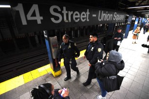 NYPD officers patrol Union Square subway station platform.