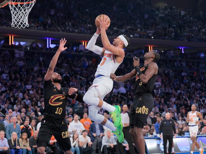 New York Knicks guard Josh Hart #3 goes up for a shot between Cleveland Cavaliers guard Darius Garland #10 and Cleveland Cavaliers guard Caris LeVert #3 during the first quarter.