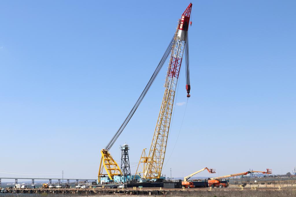 The Chesapeake 1000 crane towers over a dock at Tradepoint Atlantic in Baltimore, where it is ready to remove wreckage from the Key Bridge collapse in Maryland. Two much smaller cranes can be seen below the giant.