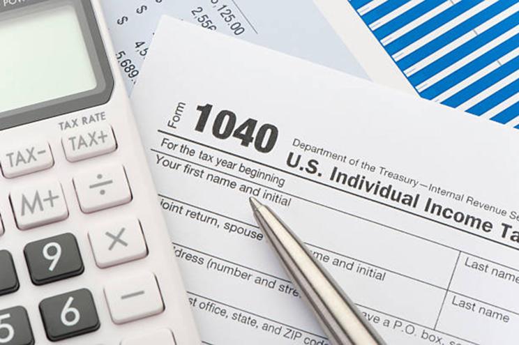 Close up of a Tax return form with a calculator.