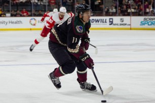 Dylan Guenther skating with the puck during Arizona Coyotes vs Detroit Red Wings hockey game on ice at Mullett Arena in Tempe, Arizona.