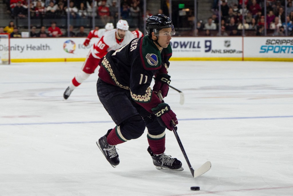 Dylan Guenther skating with the puck during Arizona Coyotes vs Detroit Red Wings hockey game on ice at Mullett Arena in Tempe, Arizona.