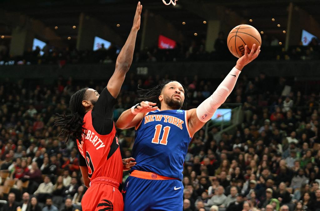 New York Knicks guard Jalen Brunson shooting a basketball against Toronto Raptors guard Javon Freeman-Liberty during a game at Scotiabank Arena.