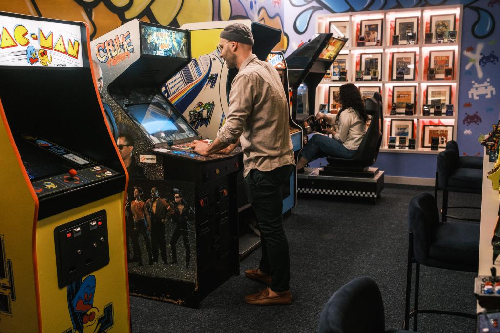 A man and a woman play 1980s style arcade games at 120 Browadway. 