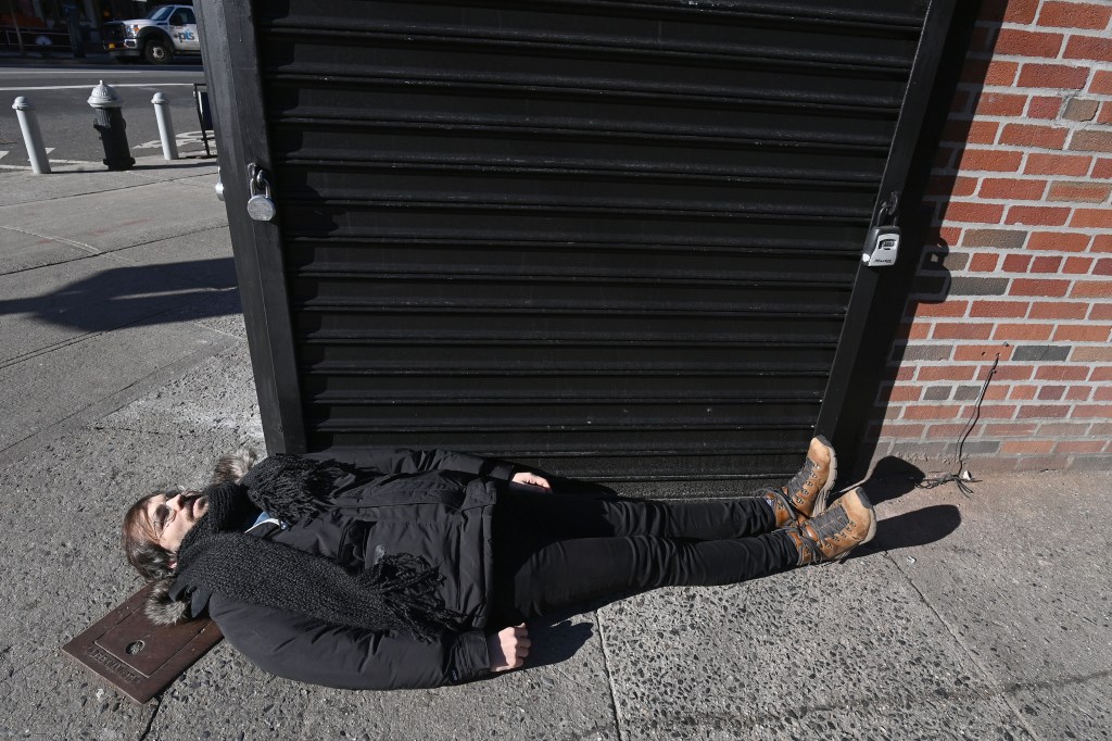 New York Post reporter Matthew Sedacca lies down on the street to show the size of a small retail space