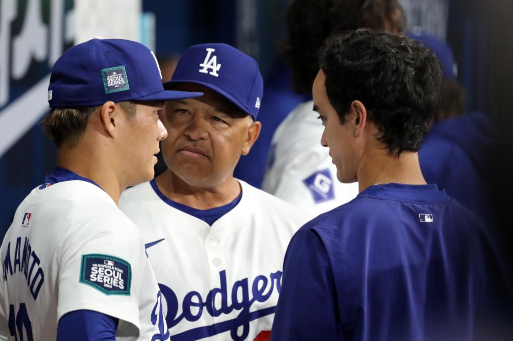 Dave Roberts (c) talks to Yoshinobu Yamamoto (l) after the first inning.