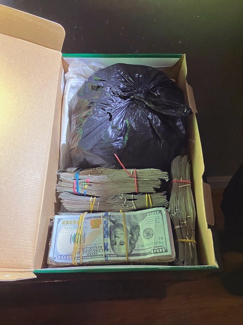 Banded stacks of cash were found along with drugs at the apartment, officials said.