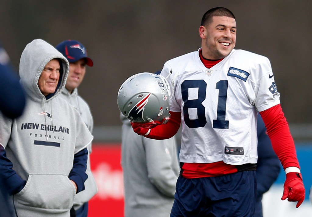 New England Patriots tight end Aaron Hernandez, right, stands on the field with head coach Bill Belichick during NFL football practice at Gillette Stadium in Foxborough, Mass. on December 19, 2012. 