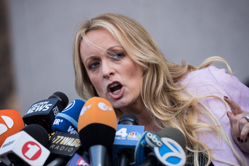 Stormy Daniels talking into mics. 