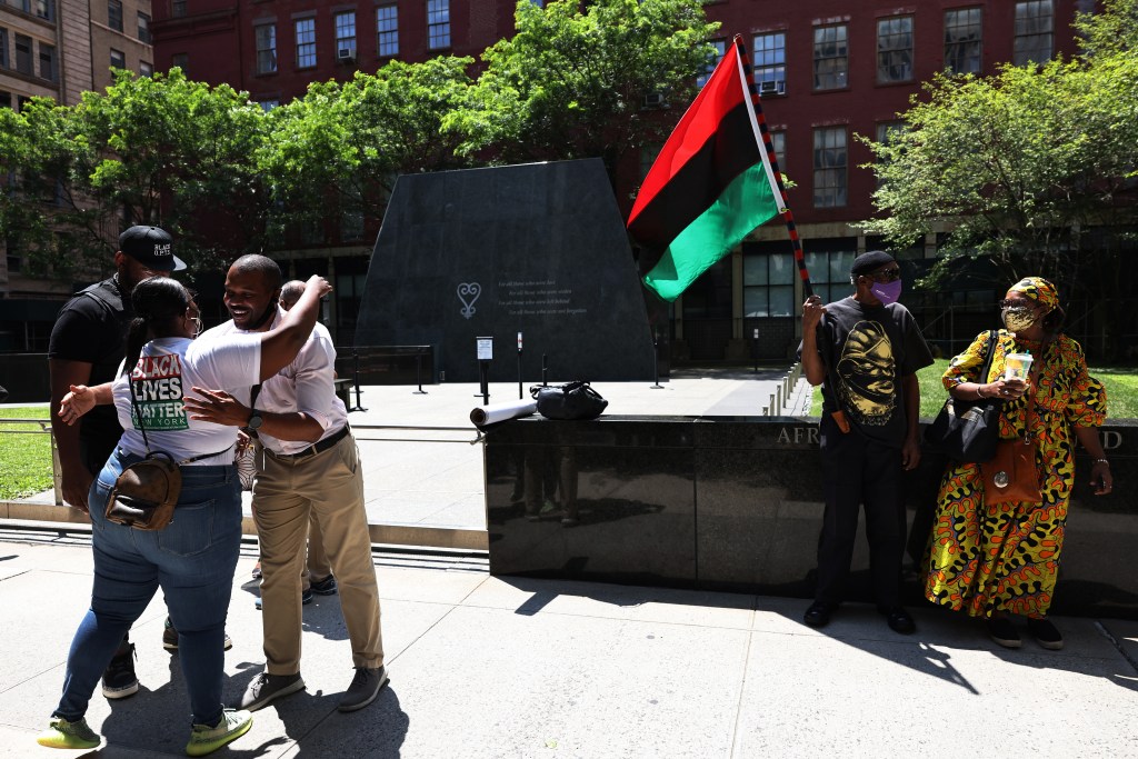 People waiting for a rally for reparations outside African Burial Ground National Monument in New York City.