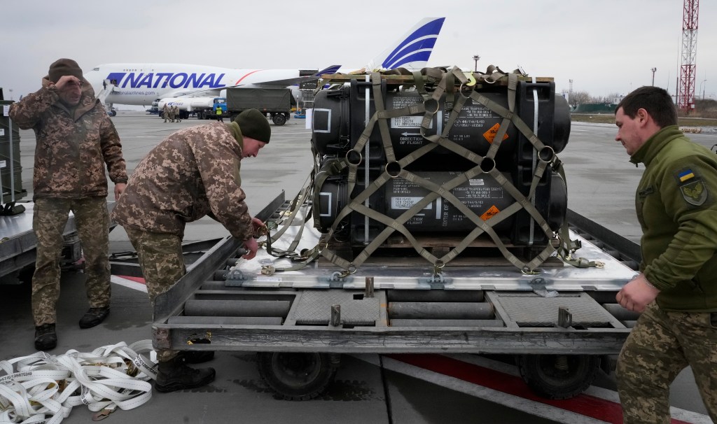 Ukrainian servicemen unpack shipment of military aid delivered.