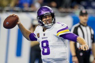 Kirk Cousins throwing a football during NFL game against Detroit Lions in 2022.