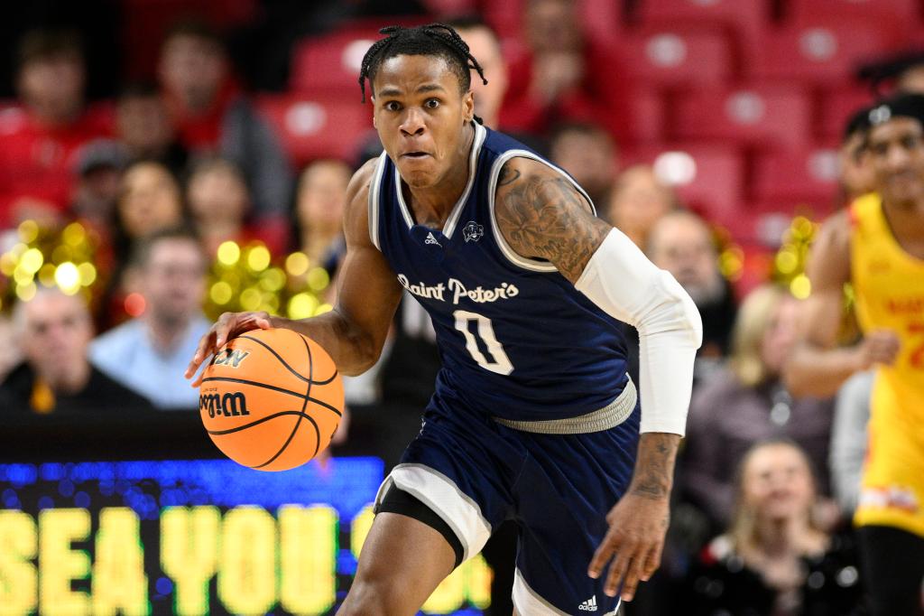 Saint Peter's guard, Latrell Reid, in a blue uniform dribbling a basketball during an NCAA college basketball game against Maryland