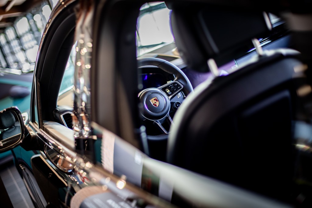 A close-up of the wheel of a Porsche Cayenne at a Porsche dealership in Rome, Italy.