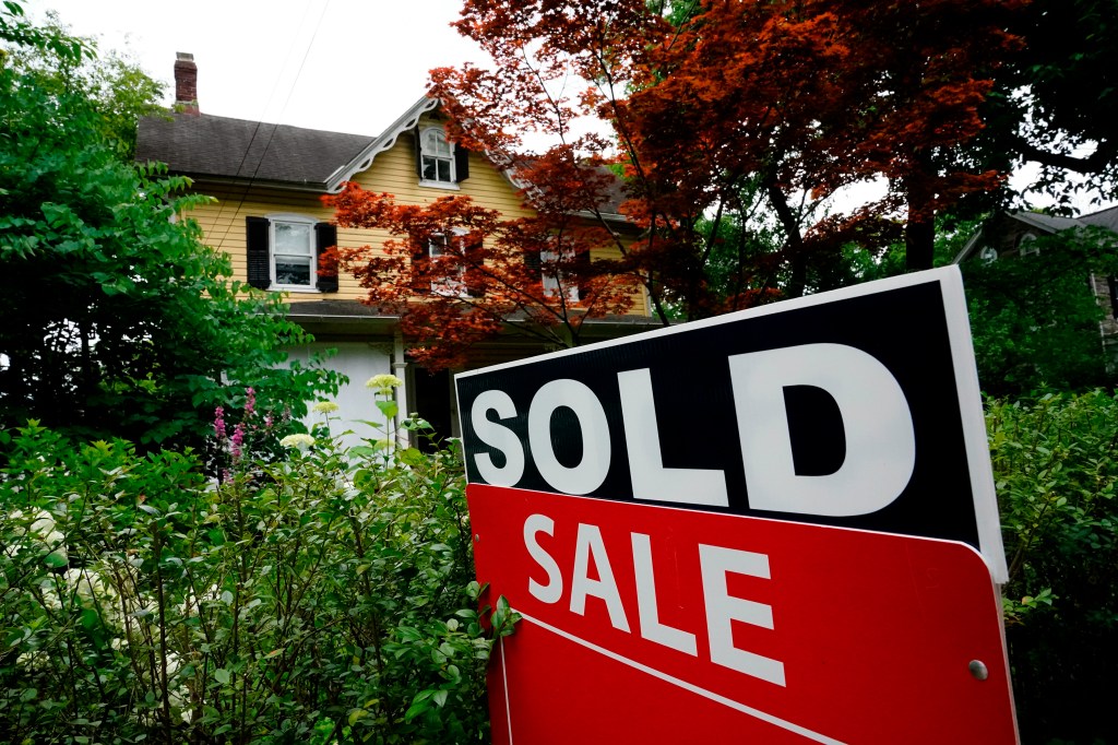 Sold sign in front of house.