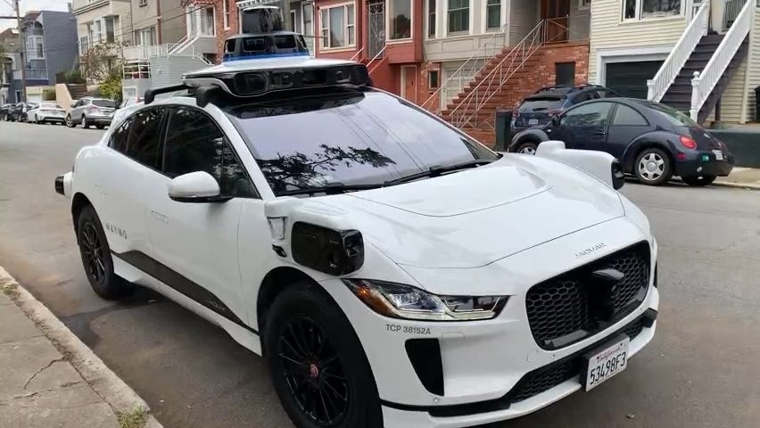 A Waymo self-driving car parked on a street in San Francisco with no driver inside.