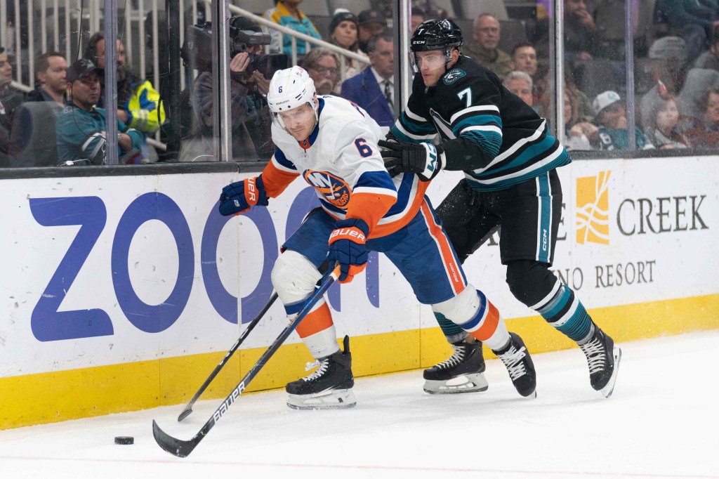 New York Islanders defenseman Ryan Pulock (6) and San Jose Sharks center Nico Sturm (7) fight for control of the puck during the second period at SAP Center at San Jose. 