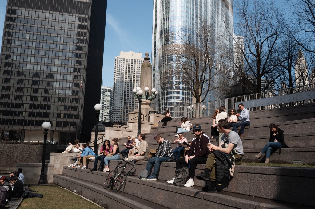 People have lunch on the Riverwalk during an unusually warm winter day in Chicago.