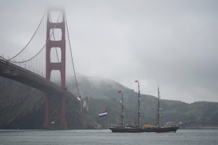 The Dutch tall ship Stad Amsterdam makes its way past the Golden Gate Bridge in San Francisco.