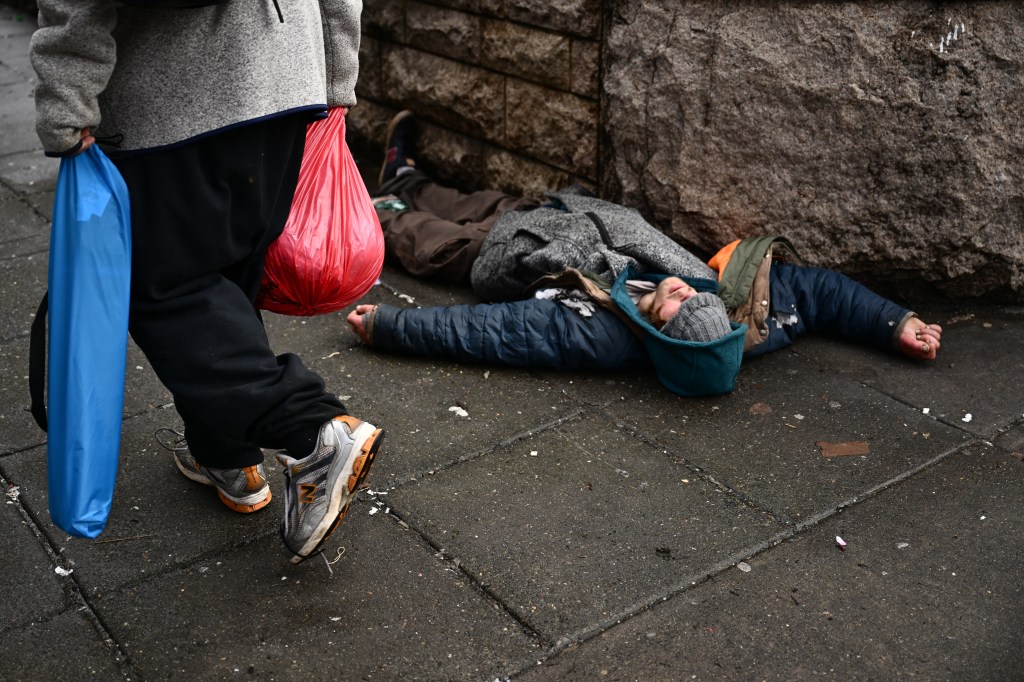 A person lays on the street in the Old Town Chinatown neighborhood of Portland on Jan. 25, 2024.