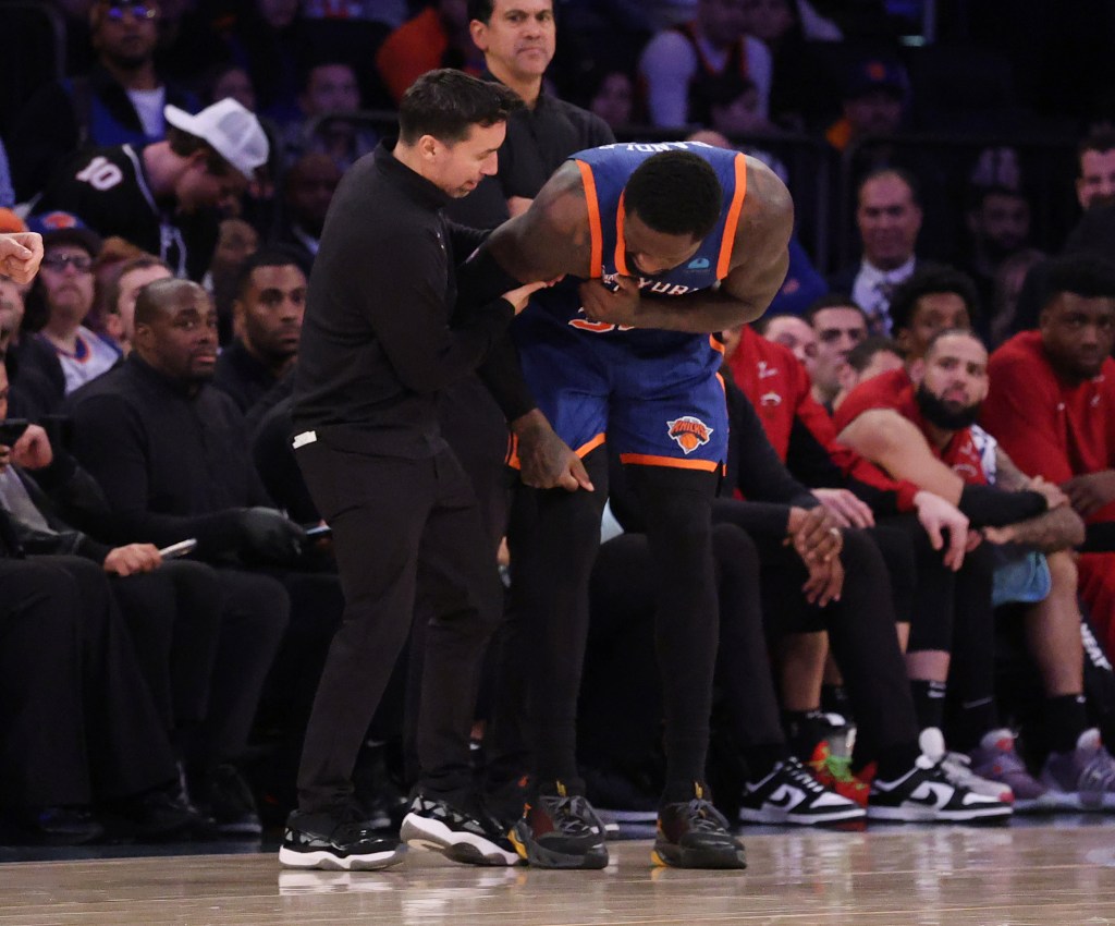 New York Knicks forward Julius Randle (30) is helped by a trainer after he goes up for a shot and falls over Miami Heat guard Jaime Jaquez Jr. (11) landing on his arm.