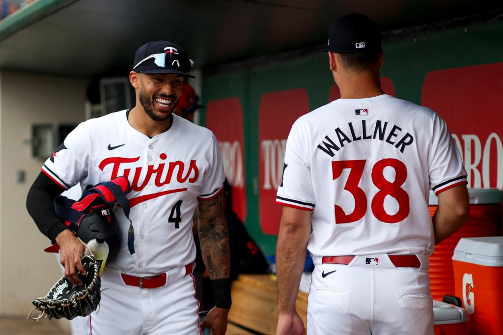 Minnesota Twins shortstop Carlos Correa (4) and starting pitcher Joe Ryan (41) get ready for a game against the Boston Red Sox at Hammond Stadium. 