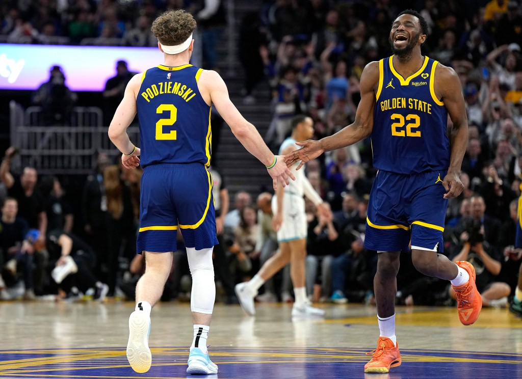 Andrew Wiggins #22 and Brandin Podziemski #2 of the Golden State Warriors celebrates after Podziemski scored against the Charlotte Hornets in the third quarter at Chase Center on February 23, 2024 in San Francisco, California.
