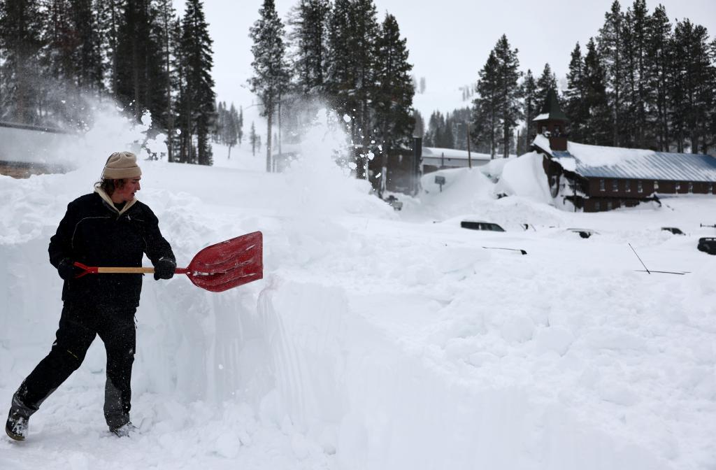 A person helps dig a friend's car out at Boreal Mountain Resort, currently shuttered due to the storm, following a massive snowstorm in the Sierra Nevada mountains on March 4, 2024 in Soda Springs, California. 