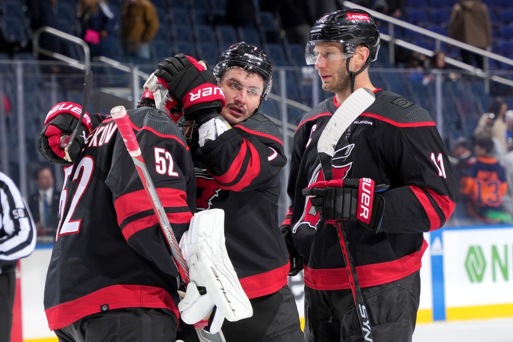  Pyotr Kochetkov #52, Dmitry Orlov #7 and Jordan Staal #11 of the Carolina Hurricanes celebrate the 4-1 win against the New York Islanders at UBS Arena on March 19, 2024 in Elmont, New York. 