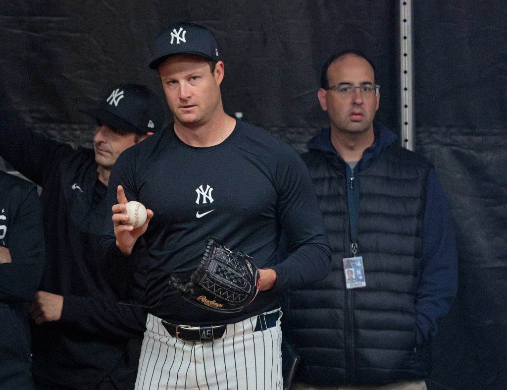 Yankees starting pitcher Gerrit Cole #45, pitching in the bullpen in front of David Grabiner, the Yankees' director of quantitative analysis