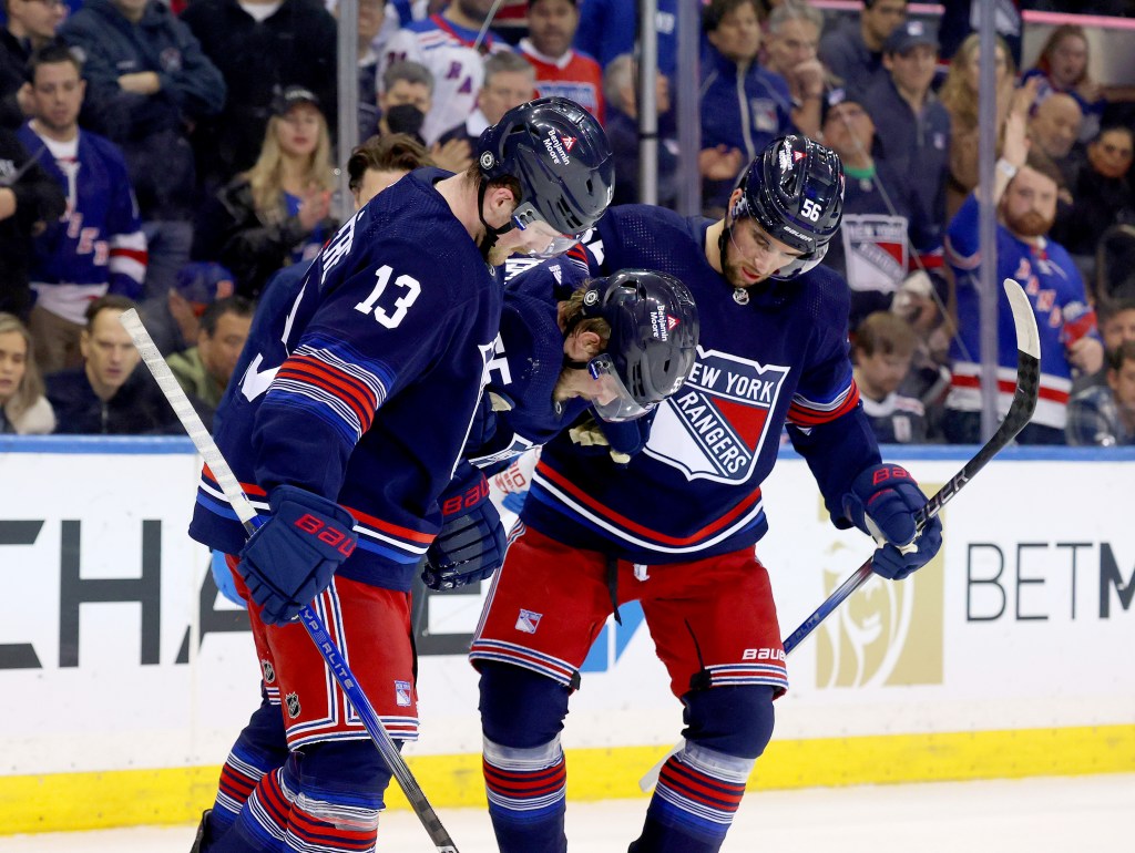 Alexis Lafreniere #13 of the New York Rangers and Erik Gustafsson #56 of the New York Rangers help Ryan Lindgren #55 of the New York Rangers off the ice