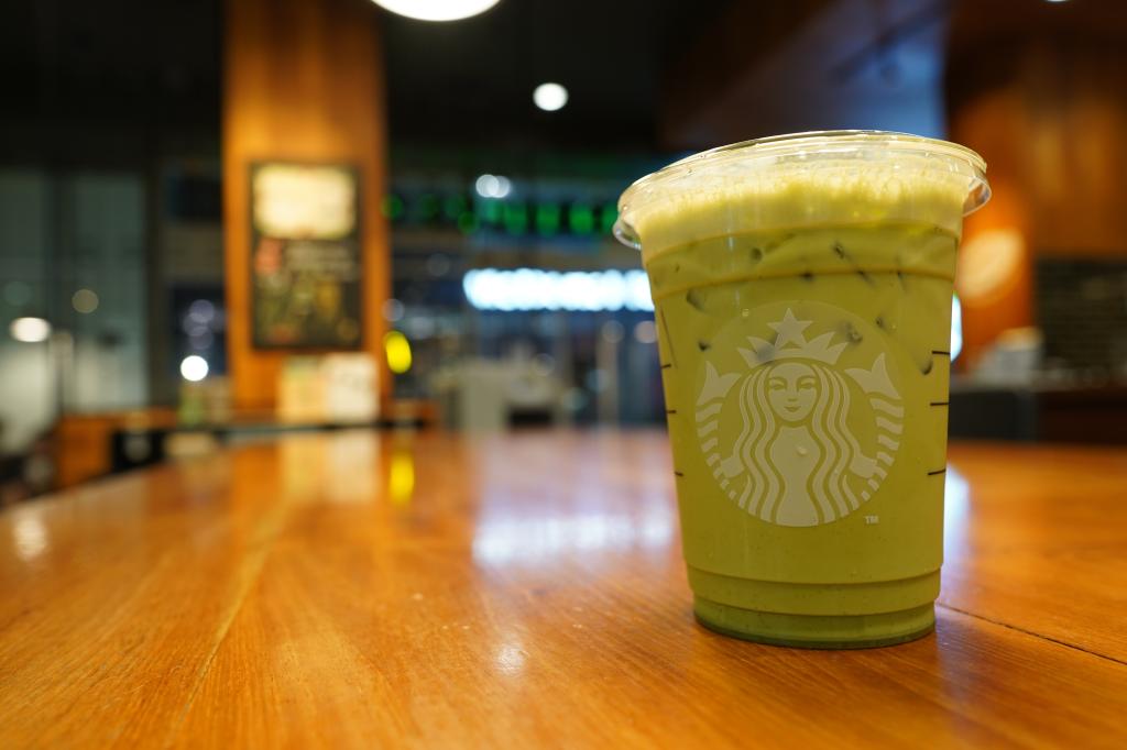 A cup of iced green tea latte on a table in Starbucks, Bangkok Thailand.