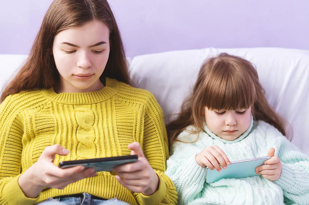 Tow girls looking at their phones.