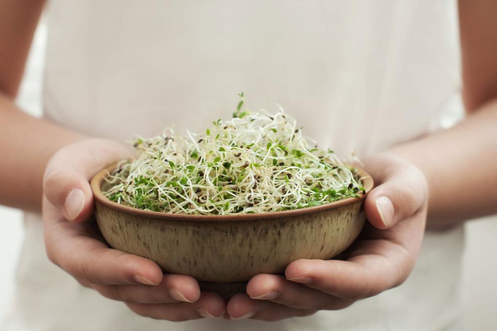 A person holding a bowl of sprouts.