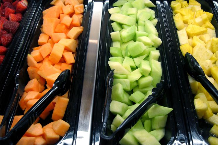 Trays of fresh fruit on display in rows.