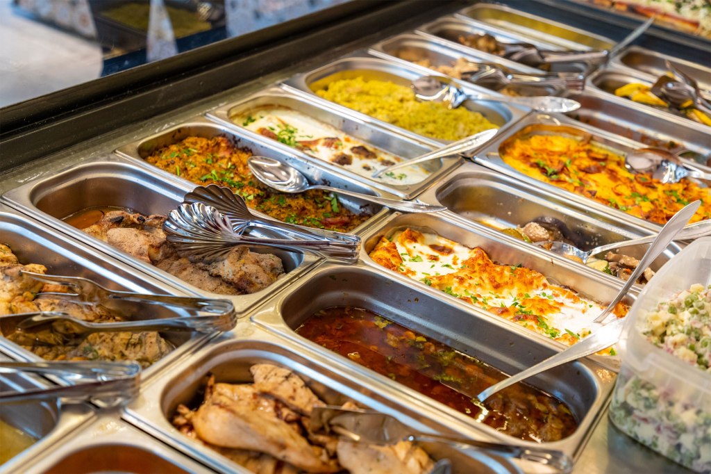 A trays of food with spoons.