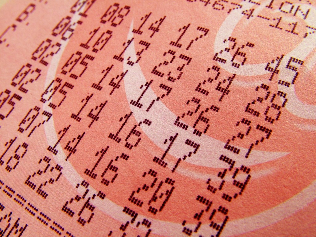 A printed paper with text and numbers on it, including a Mega Ball number, and an extra number that went far.