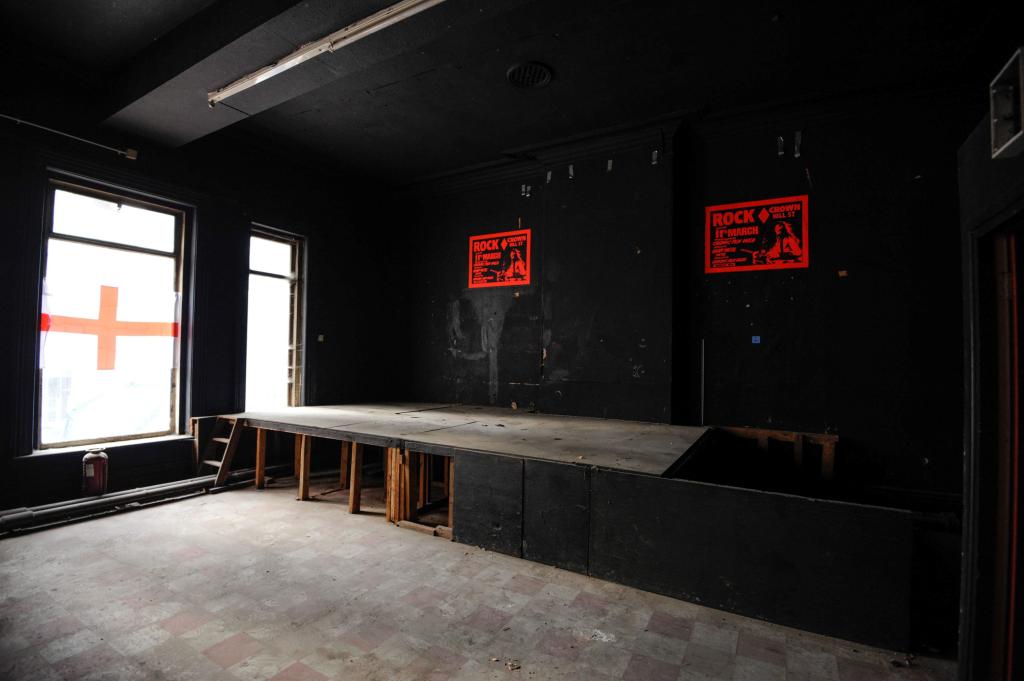 Black Sabbath's first gig stage with red signs on the wall.