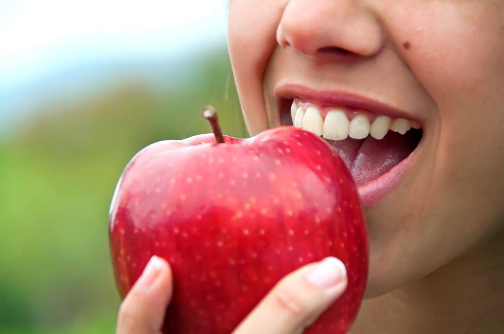 A woman biting into an apple