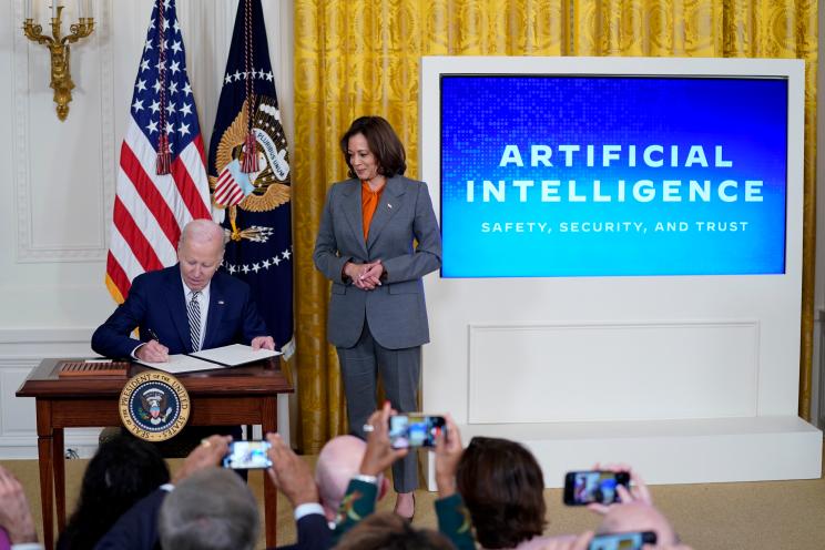 A photo of President Biden and Vice President Harris as the president signs an ambitious artificial intelligence bill.