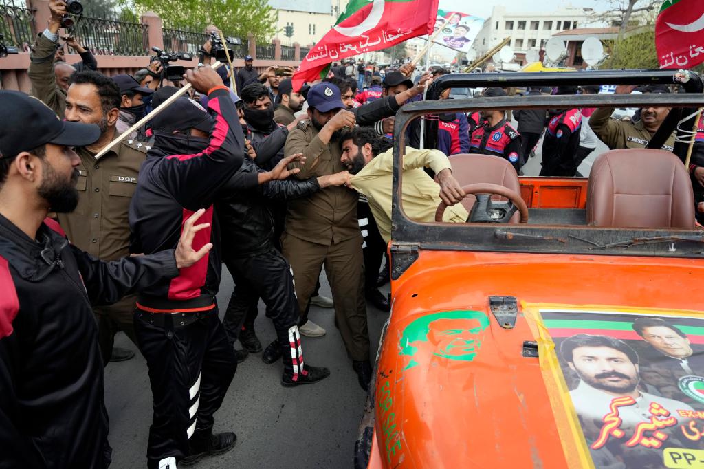 Security personnel detain supporter of Former Prime Minister Imran Khan's during a protest against the Pakistan Election Commission, in Lahore, Pakistan, Saturday, March 2, 2024. (AP Photo/K.M. Chaudary)