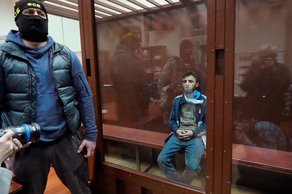 Dalerdzhon Mirzoyev sitting in a glass cage in the Moscow court.