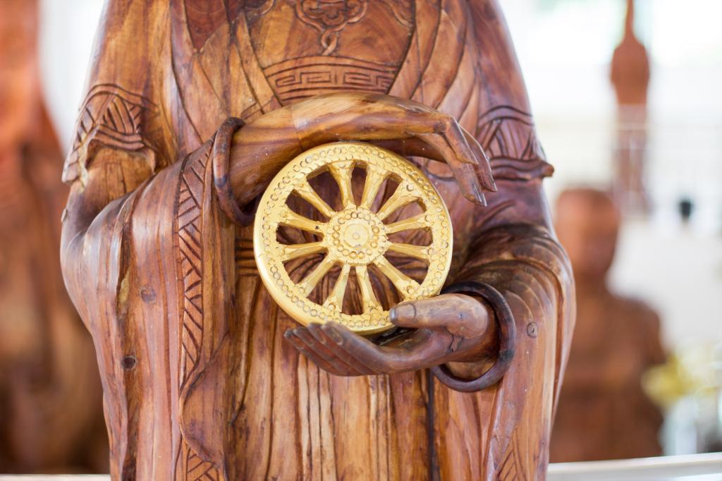 Carved wooden buddha hand Holding Dharmachakra.